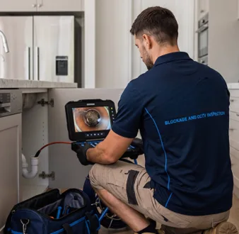 Plumber clearing a blocked toilet in a Holsworthy bathroom